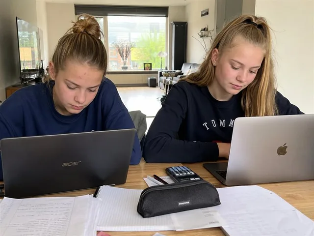 Photo: two students studying together at the kitchen table during test week.